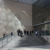 People walk up and down the steps outside the San Diego Central Courthouse in downtown San Diego.
